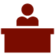 An illustration of a red figure seated at a red desk. 
