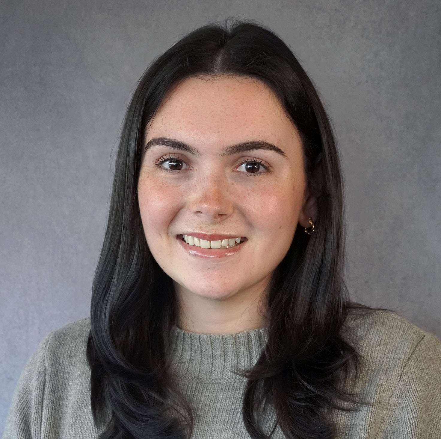 an individual with long dark hair wearing a sweater